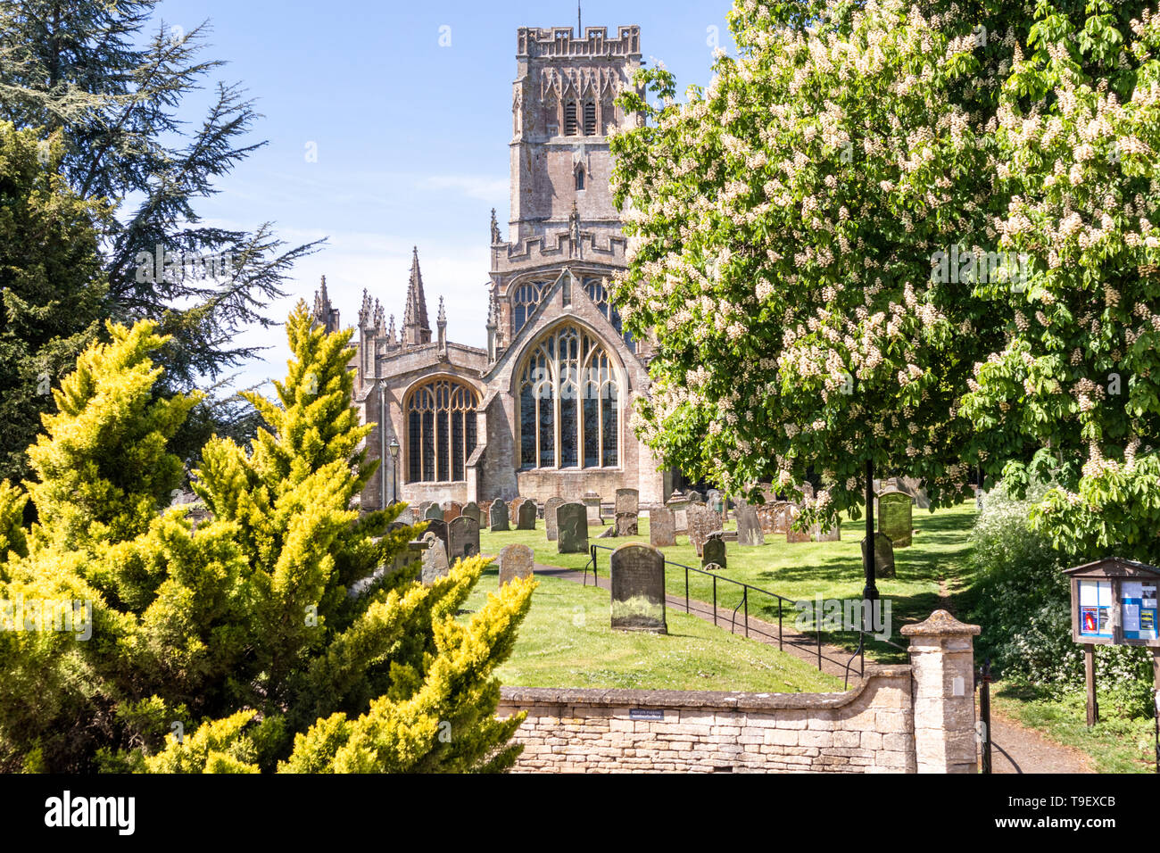 Maytime al Cotswold lana chiesa di San Pietro e San Paolo a Northleach, Gloucestershire, England Regno Unito - La torre di campane, tramite un carillon, alle ore Foto Stock