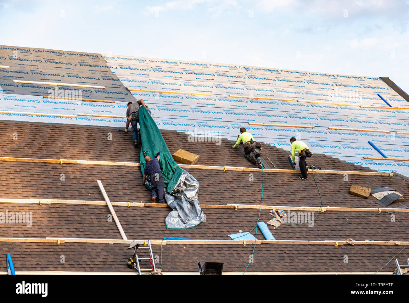 King of Prussia, PA - 2 Maggio 2019: Conciatetti installazione CertainTeed prodotti di copertura su un tetto di grandi dimensioni. CertainTeed Corporation è un North American manufa Foto Stock