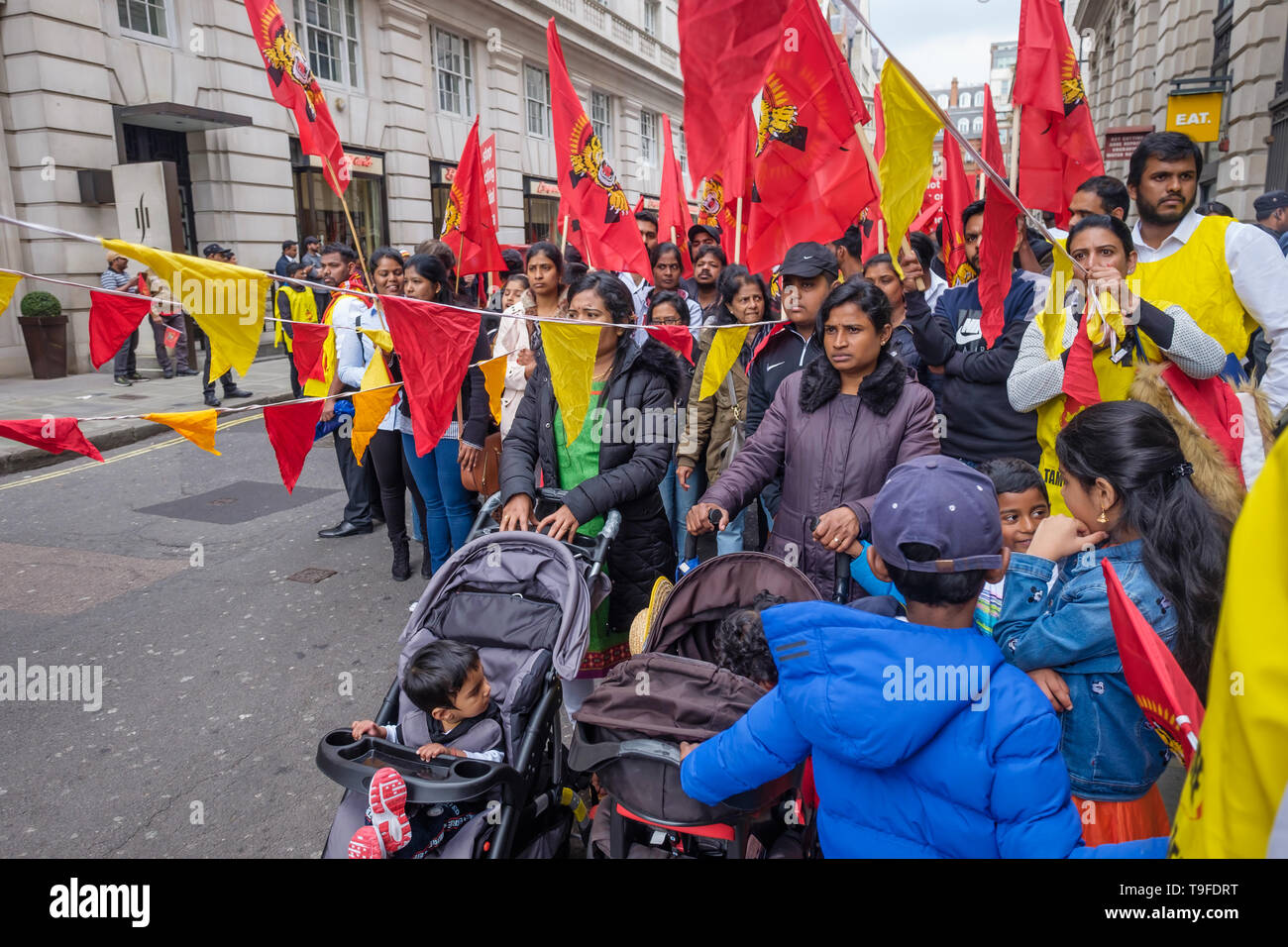 Londra, Regno Unito. Il 18 maggio 2019. Donne e chilren attendere presso la parte anteriore del marzo da diverse migliaia di Tamil, molti con Tamil Eelam bandiere, attraverso Londra Mullivaikkal sul giorno del ricordo nella memoria di quelli uccisi da Sri Lanka assassina guerra contro i tamil, che si è conclusa a dieci anni fa. Per questo chiedono una soluzione politica che dà tamil indietro il controllo della loro patria del Tamil Eelam, e per la fine dell embargo sulle Tigri Tamil. Commemorazioni di pubblico di molte migliaia di vittime della guerra sono vietate in Sri Lanka. Peter Marshall / Alamy Live News Foto Stock