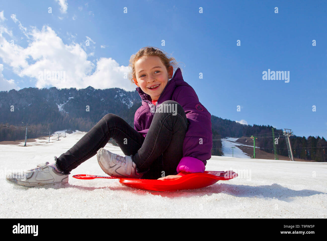 Sorridente ragazza divertirsi su una scheda di bum Foto Stock