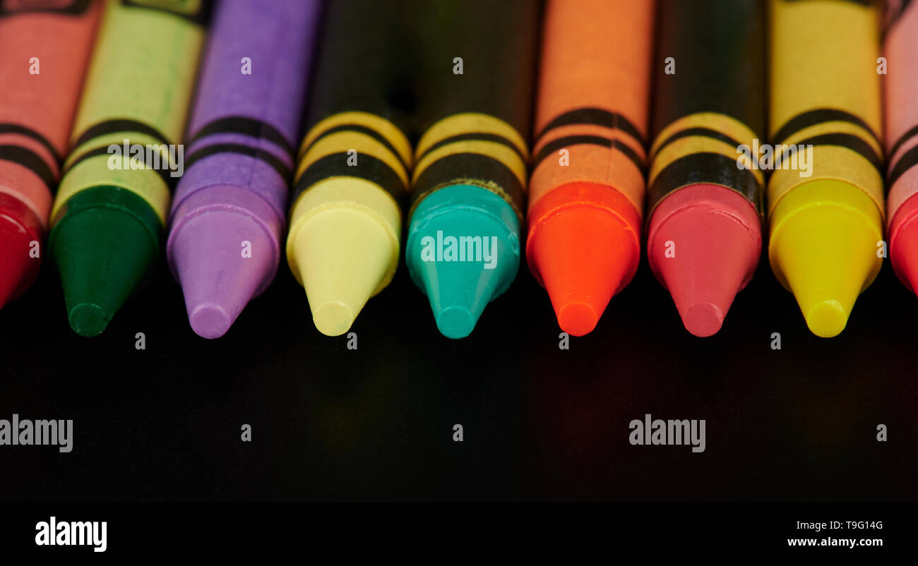 Close up di matite colorate su sfondo nero Foto Stock