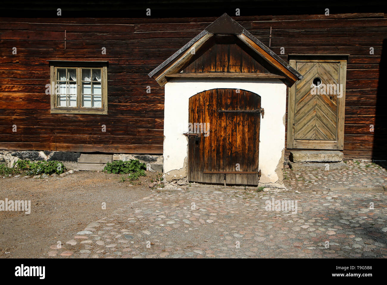 Un dettaglio del vecchio scandinavo casa in legno. La casa è vecchia e look trasandato ma ancora ben mantenuto. Una finestra può e i due porta di ingresso c Foto Stock