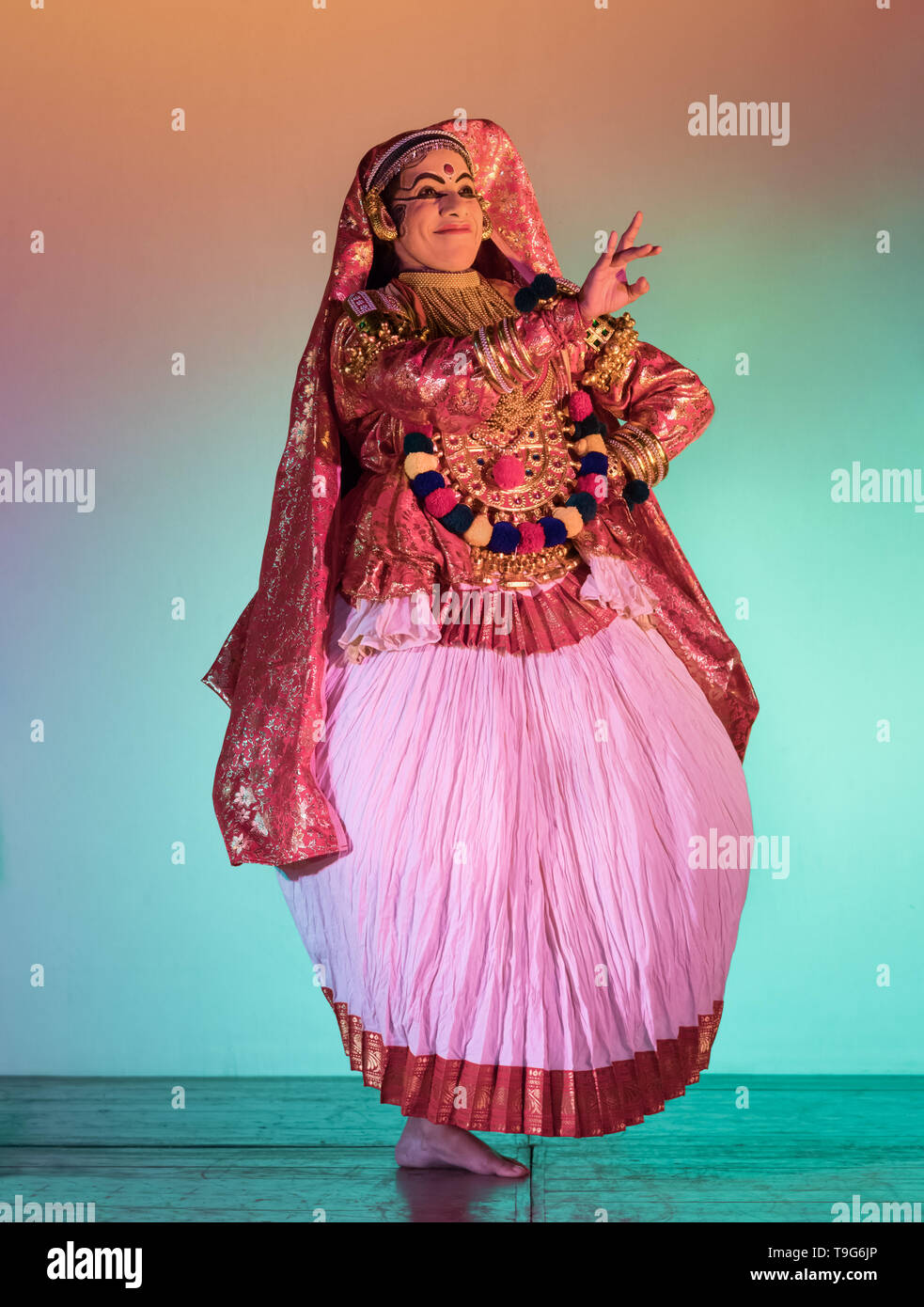 Un ballerino Kathakali che esegue una danza classica del sud dell'India sul palco in completo costume stile Minikku, con ornamenti ed espressioni. Foto Stock