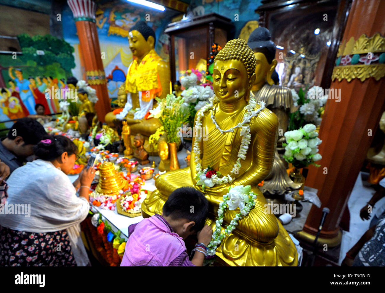 Un bambino visto pregare davanti alla statua di Buddha Signore durante il Buddha Purnima preghiere. Il Buddha il compleanno è una vacanza tradizionalmente celebrato nella maggior parte dell Asia orientale per commemorare la nascita del Principe Siddharta Gautama o Gautama Buddha che è il fondatore del buddhismo. Foto Stock