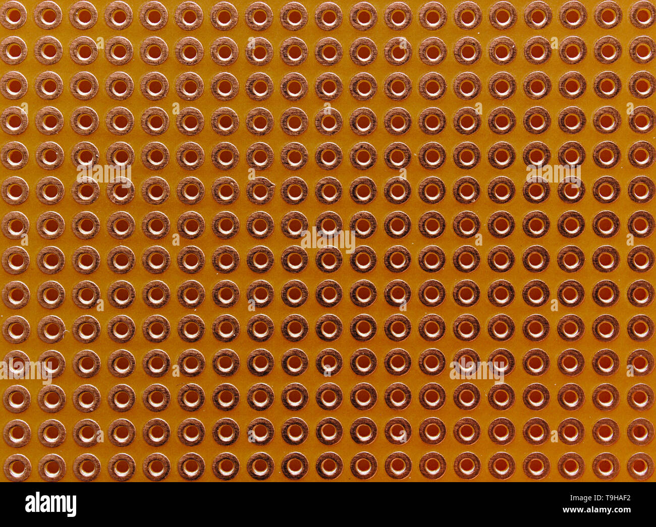 Vuoto per scheda a circuito stampato in rame con fori rivestiti per diy i progetti elettronici. Close up sfondo senza giunture. Foto Stock