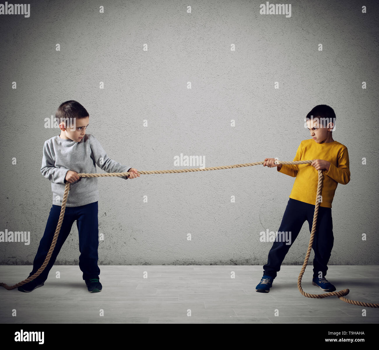 La rivalità di due fratelli che hanno una corsa con una corda Foto Stock