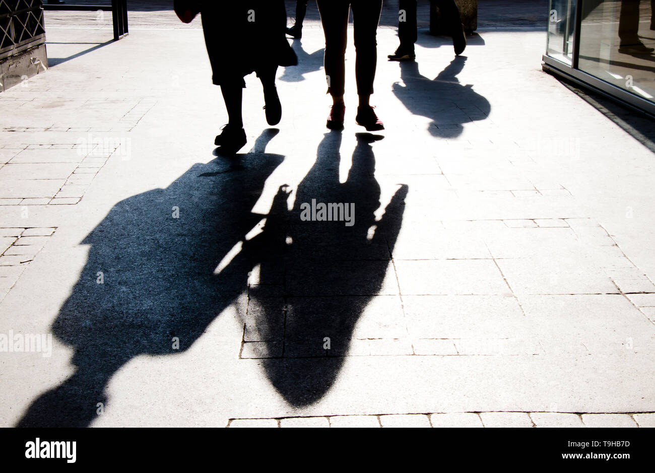 Sfocata ombra silhouette di persone a piedi la città sulla strada pedonale in alto contrasto bianco e nero Foto Stock