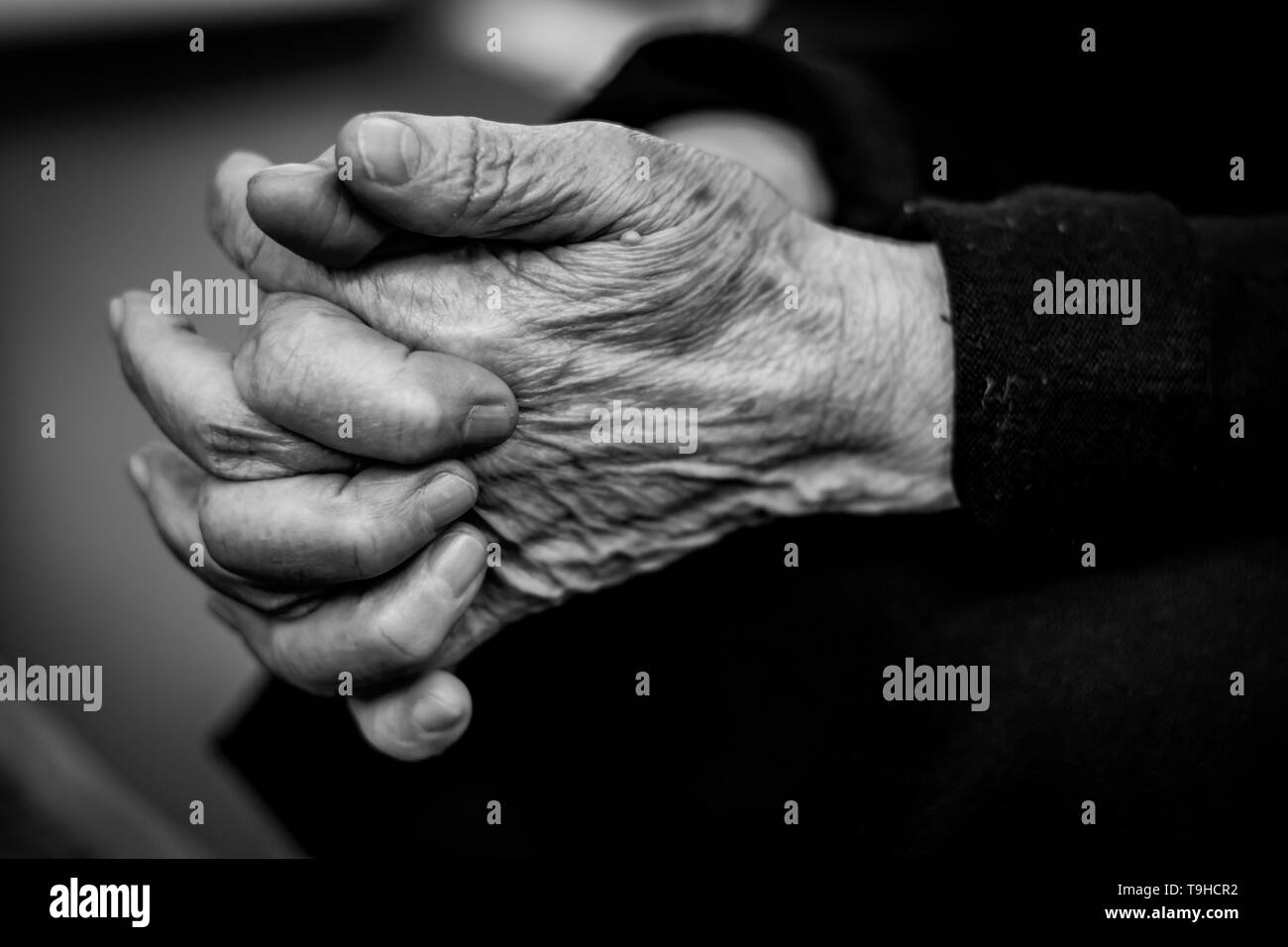 Vecchia donna dita incrociate vicino, pelle rugosa - bianco e nero Foto Stock