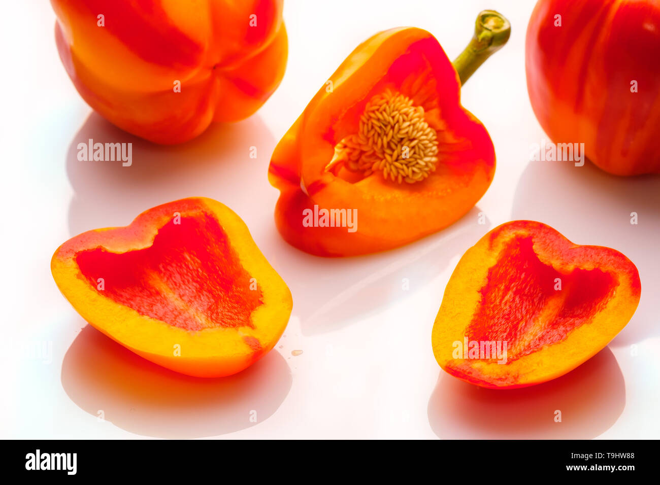 Pepe vegetali di colore arancione-rosso su bianco con la riflessione Foto Stock