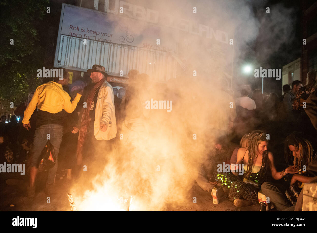 Bristol, Avon, Regno Unito. Il 19 maggio 2019. Migliaia di festaioli hanno percorso le strade di Bristol a partecipare più popolari della città tutti i giorni di parti. Rave on Avon ha assunto la Stokes Croft area del sud ovest di città per l' ultima volta che per primo ha avuto luogo 11 anni fa ma con Stokes Croft diventando sempre più gentrified, gli organizzatori del leggendario evento annunciato in febbraio che avrà una nuova casa il prossimo anno. Nella foto: festaioli raccogliersi attorno a un fuoco al Turbo Isola, Stokes Croft, Bristol. Credito: Lee Thomas/Alamy Live News Foto Stock