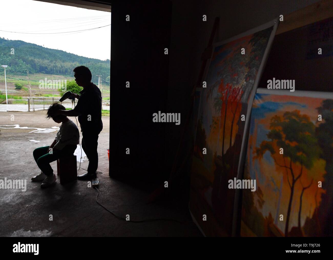 (190519) -- NANCHANG, 19 maggio 2019 (Xinhua) -- Lin Fusheng (R) aiuta a sua figlia di asciugare i capelli in casa loro a Lichuan County, Cina orientale della provincia di Jiangxi, 15 maggio 2019. Lin Fusheng, un abitante di un villaggio da Hualian villaggio di Huashan township di Lichuan County, subito da handicap fisico a causa della paralisi infantile. Nonostante che, Lin bloccato con il suo sogno di diventare un pittore. Come Lichuan County assistito a un rapido sviluppo dell industria della pittura a olio nel 2013, Lin è ritornato nella sua città natale e cresciuto come un pittore professionista con l aiuto del governo locale. Ora Lin possiede uno studio a un olio Foto Stock