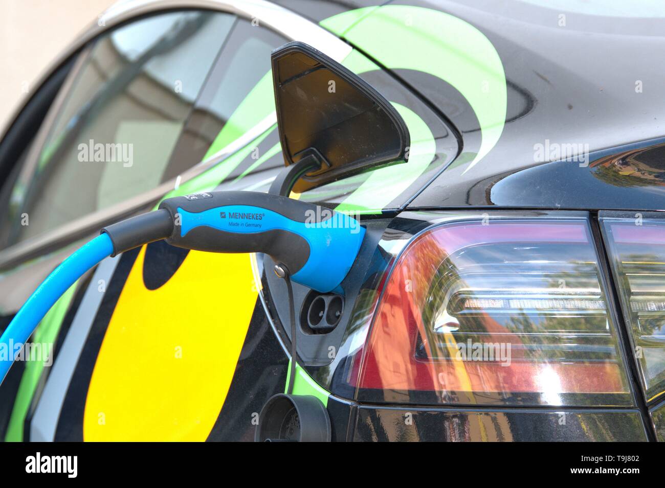 Schleswig, Deutschland. 19 Maggio, 2019. 19.05.2019, un modello di Tesla 3 veicolo elettrico viene caricato withtels un tappo di carica della Società Mennekes sul Gottorfer Landmark. Dettaglio del processo di carica. | Utilizzo di credito in tutto il mondo: dpa/Alamy Live News Foto Stock