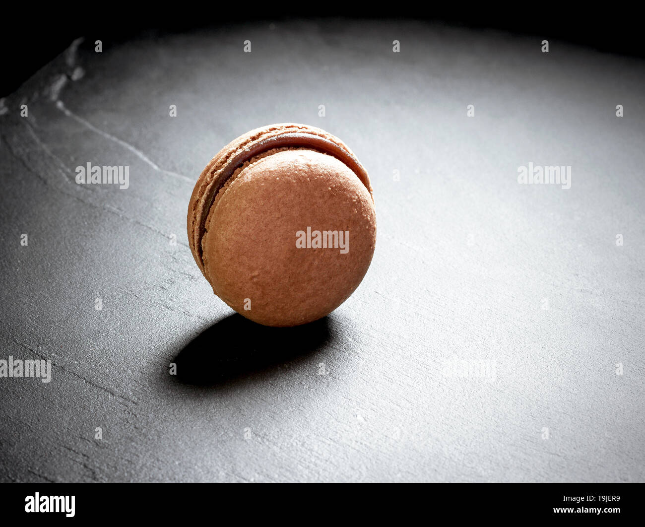 Il cioccolato macaron a sfondo nero, close up Foto Stock