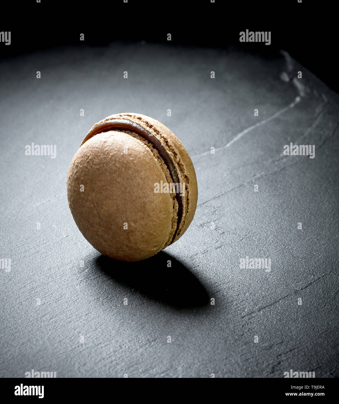 Il cioccolato macaron a sfondo nero, close up Foto Stock
