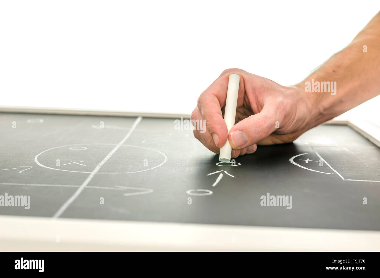 Vista laterale di una parte di scrivere un gioco di calcio strategia su una lavagna. Su sfondo bianco. Foto Stock