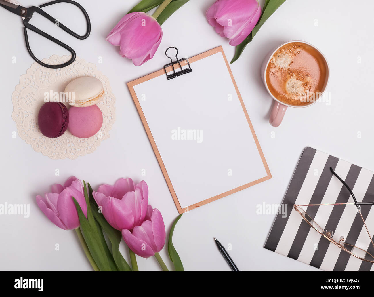 Stile femminile luogo di lavoro con tulipani e caffè. Appunti mock-up Foto Stock