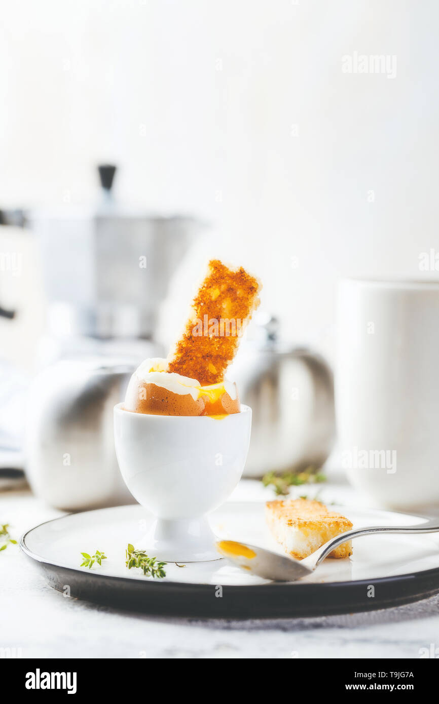 Uova sode per la colazione con pane tostato e la tazza di caffè in background Foto Stock