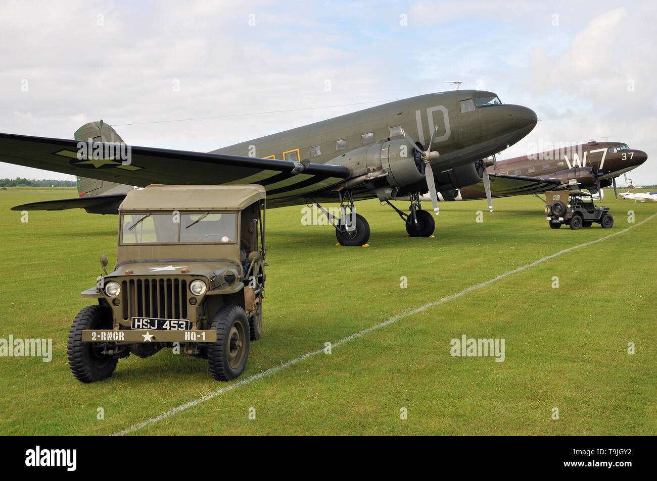 Douglas C-47 Skytrain piano di trasporto nel periodo marcature camouflage - compresi D giorno 'invasione strisce' - con Willys MB Jeep. Whiskey sette. Aerei Foto Stock