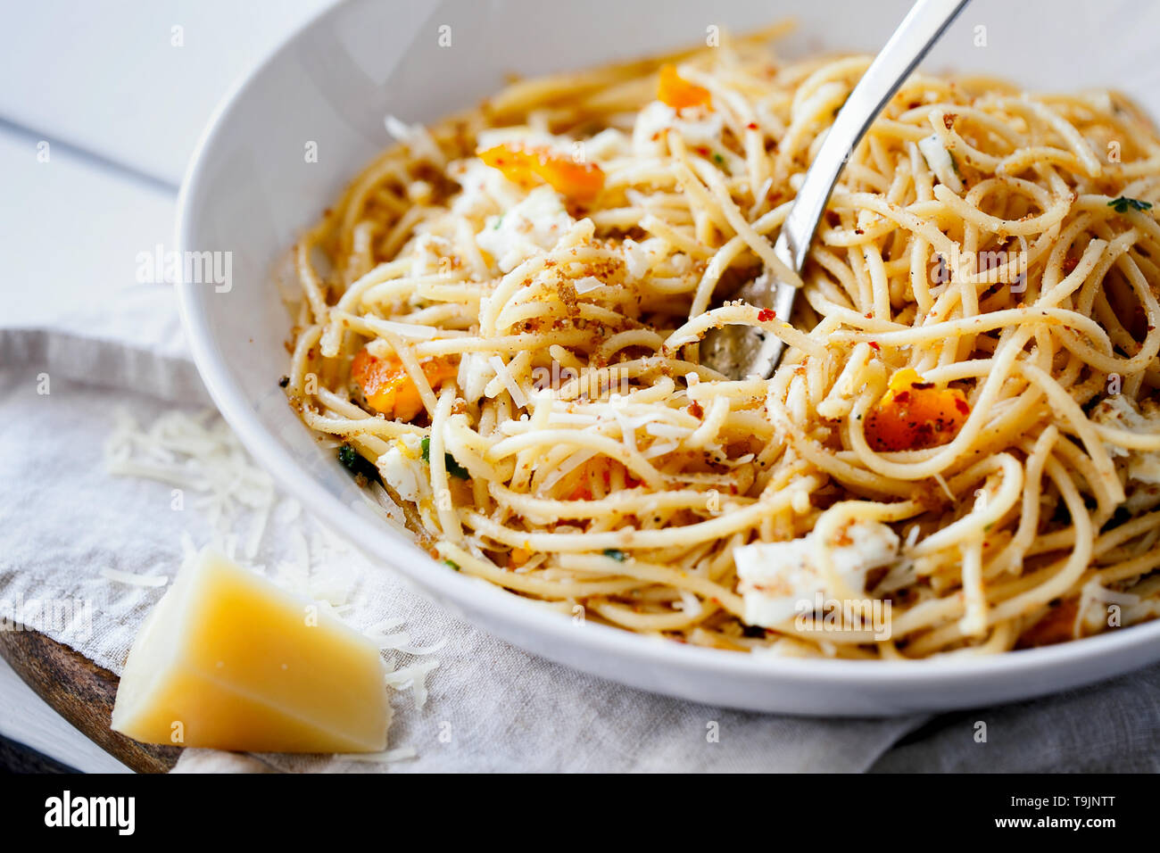 Veloci e deliziosi piatti di pasta italiana spaghetti con uova fritte, pangrattato e parmigiano grattugiato sulla piastra bianca di close-up.freschi cibi fatti in casa Foto Stock