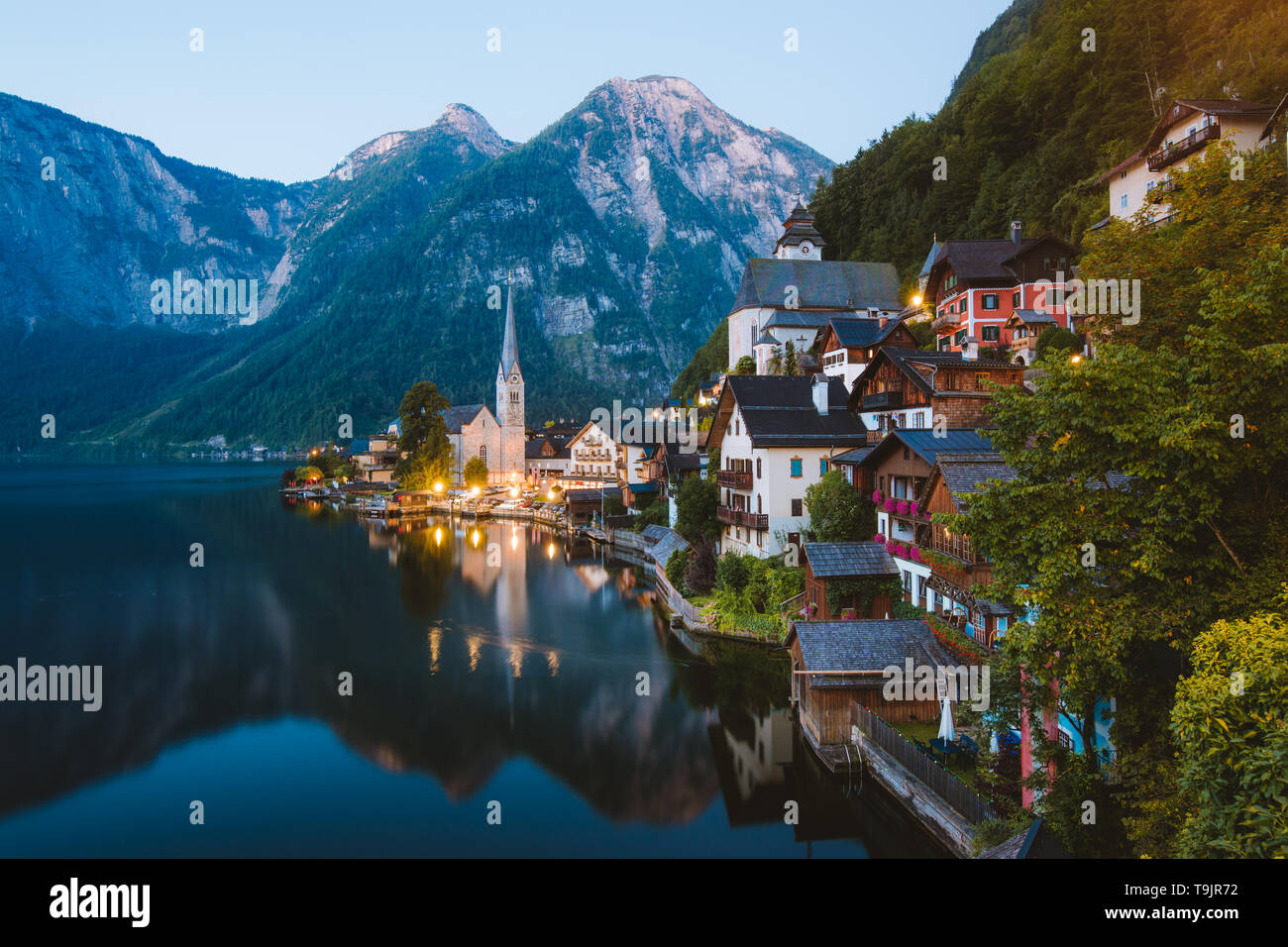 Classic vista da cartolina famosa Hallstatt villaggio di montagna con Hallstattersee nelle Alpi austriache a mystic twilight durante ore blu all'alba nella somma Foto Stock