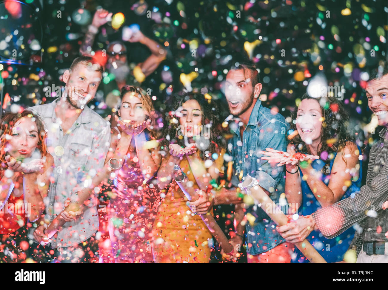 Happy amici facendo parte gettando coriandoli nel club - Millennial giovani divertirsi celebrando in discoteca Foto Stock