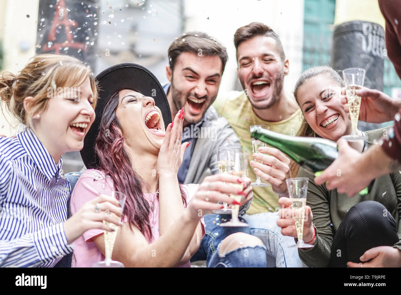 Gruppo di happy amici facendo parte gettando coriandoli e bere champagne outdoor - Giovani avendo divertimento festeggia il compleanno insieme Foto Stock
