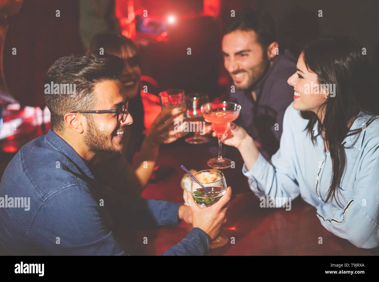 Happy amici e bere cocktail di tostatura in un jazz bar - Giovani il tifo e ridere insieme in un club di notte Foto Stock