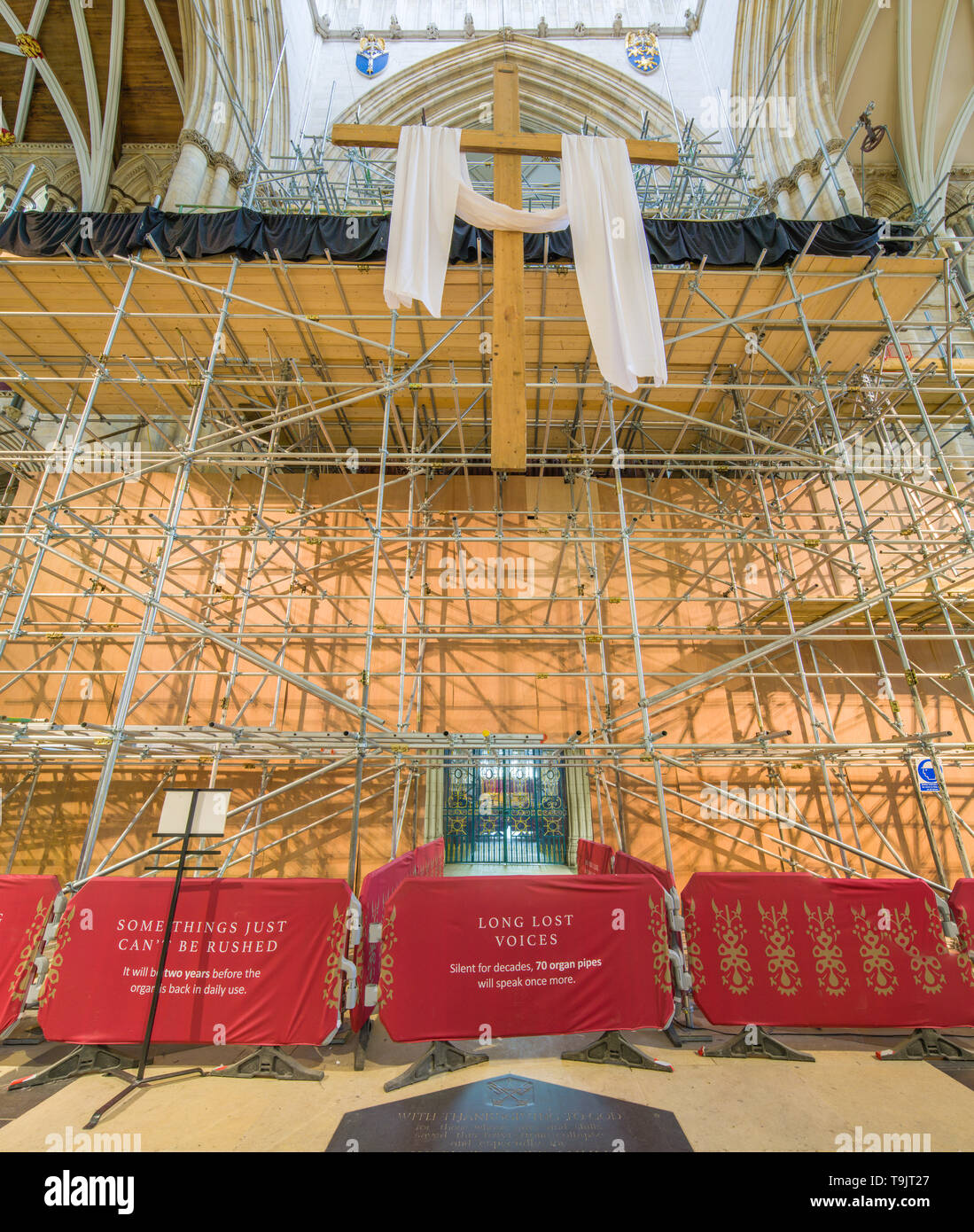 Croce vuota con protezione incarto (simboli della risurrezione di Gesù Cristo) al di sotto della torre e di fronte all'organo ponteggio a York Minster. Foto Stock