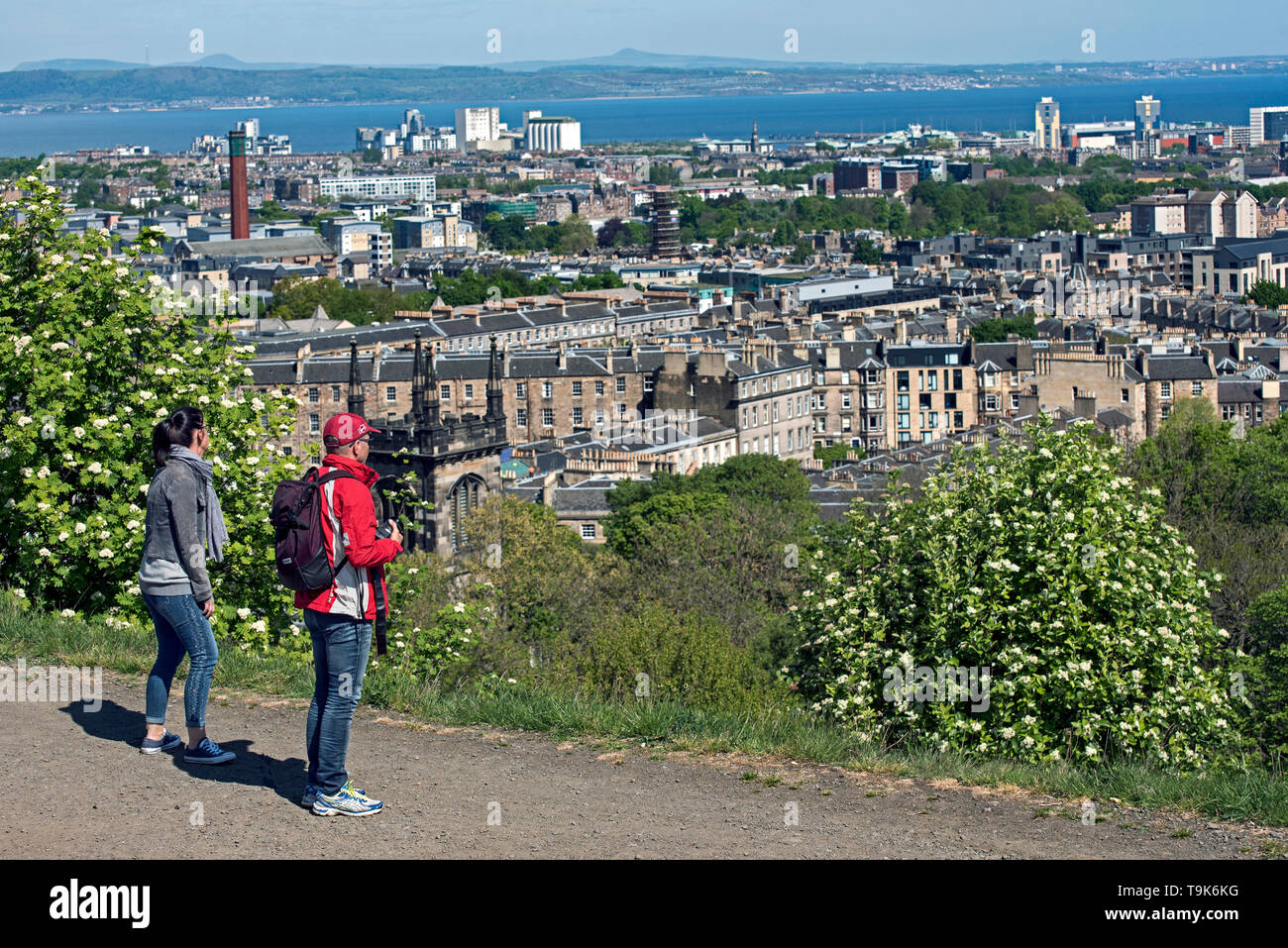 I turisti su Calton Hill prendere nelle viste di Leith, Leith e sul Firth of Forth. Foto Stock