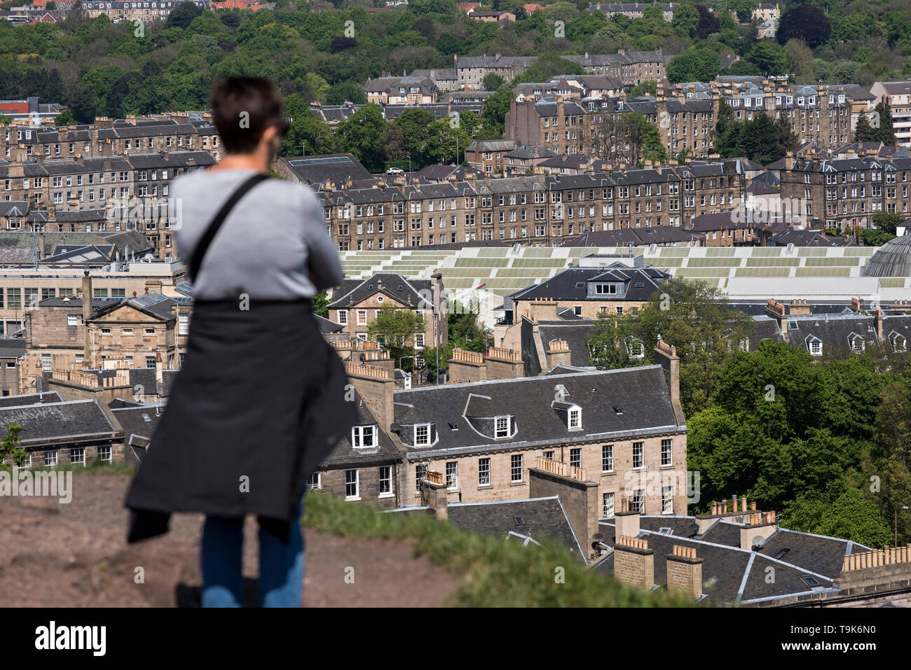 Una donna si erge su Calton Hill tenendo in vista del nord, Edimburgo , in Scozia, Regno Unito. Foto Stock