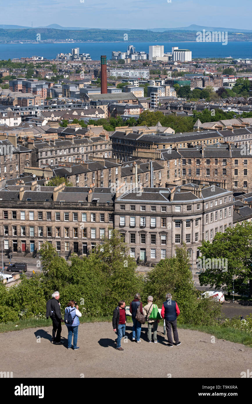 I turisti su Calton Hill prendere nelle viste di Leith, Leith e sul Firth of Forth. Foto Stock