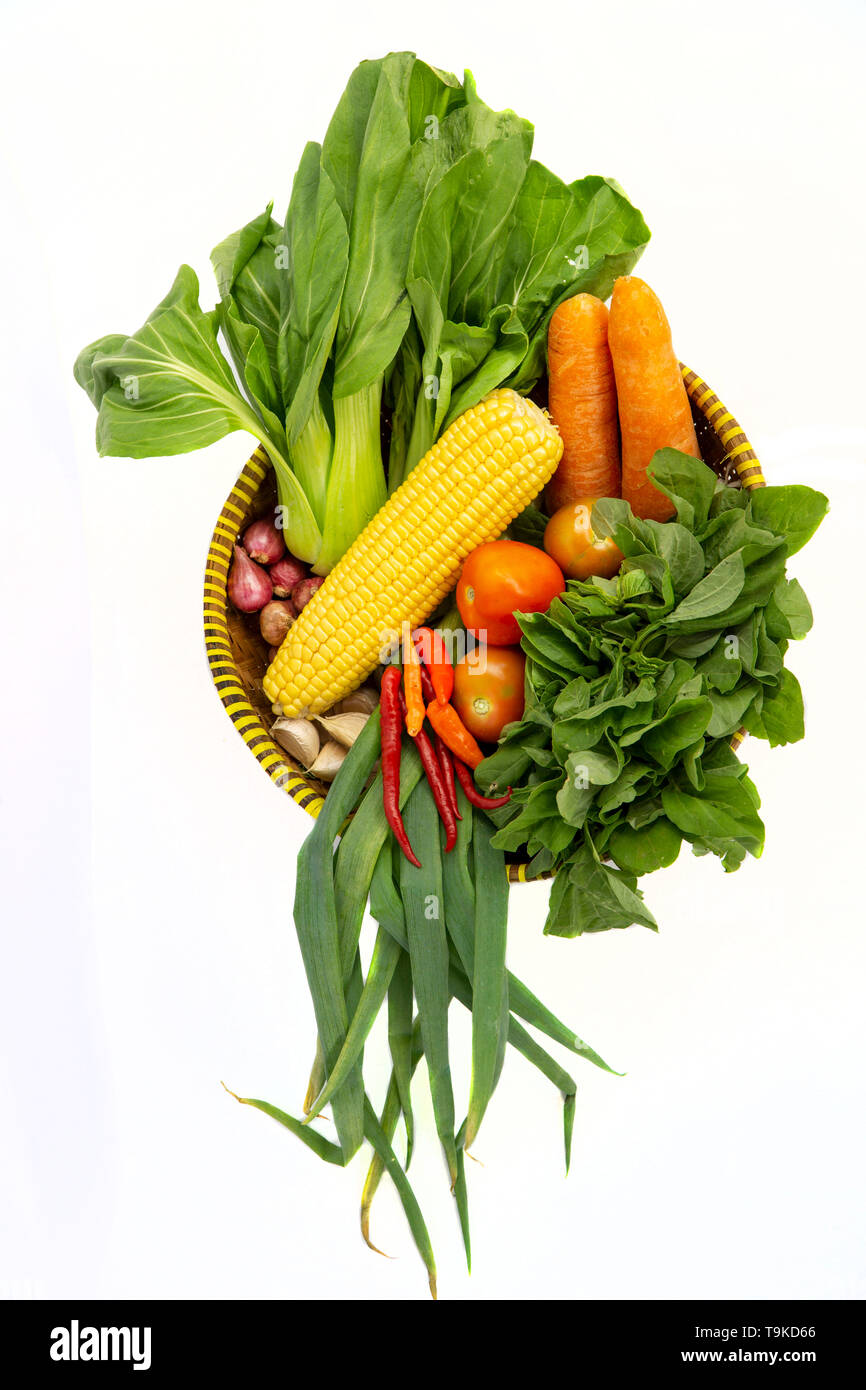 Vista superiore di vari ortaggi freschi in un cestello di bambù isolati su sfondo bianco Foto Stock