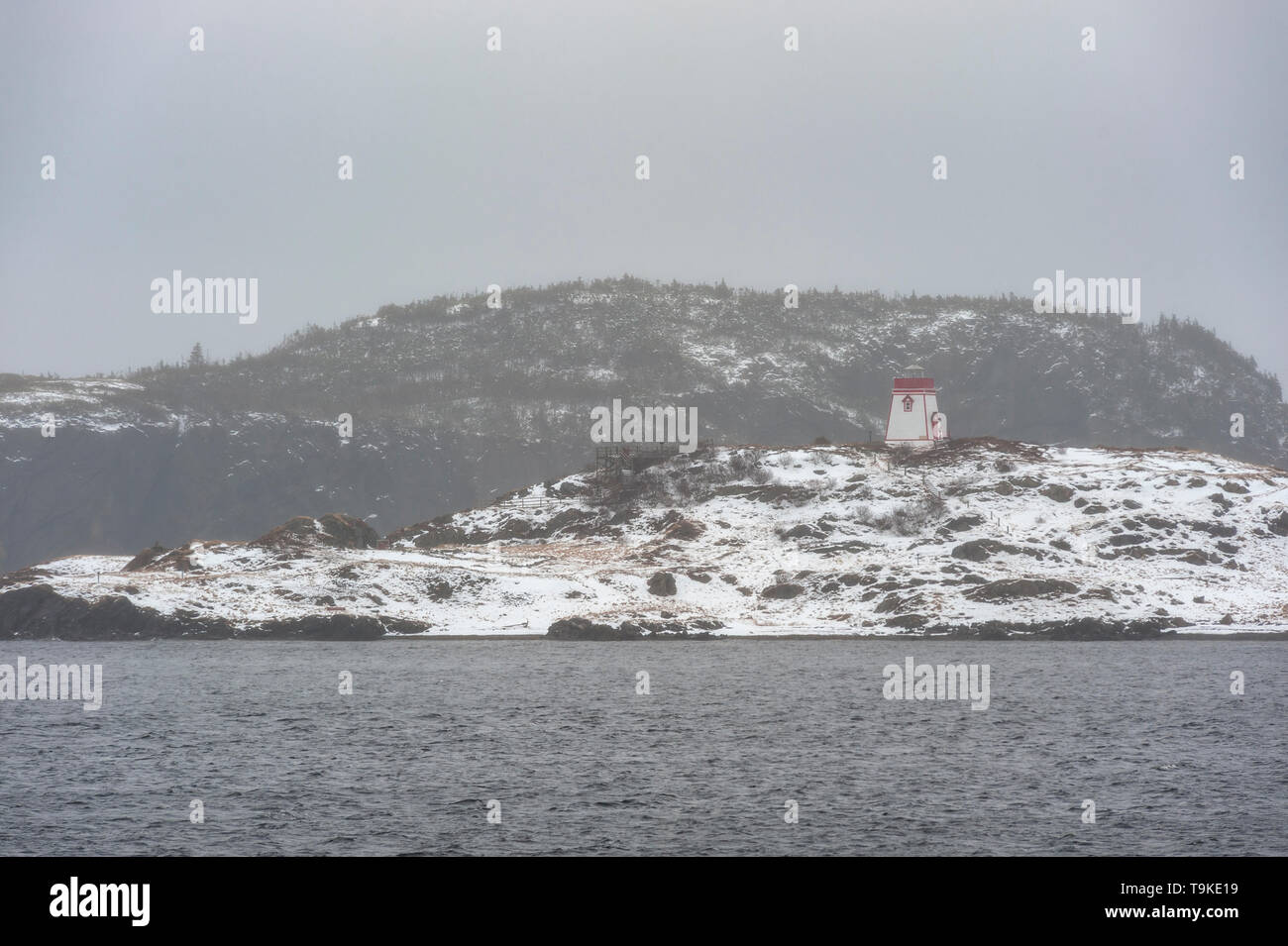 Faro sulla coperta di neve litorale Foto Stock