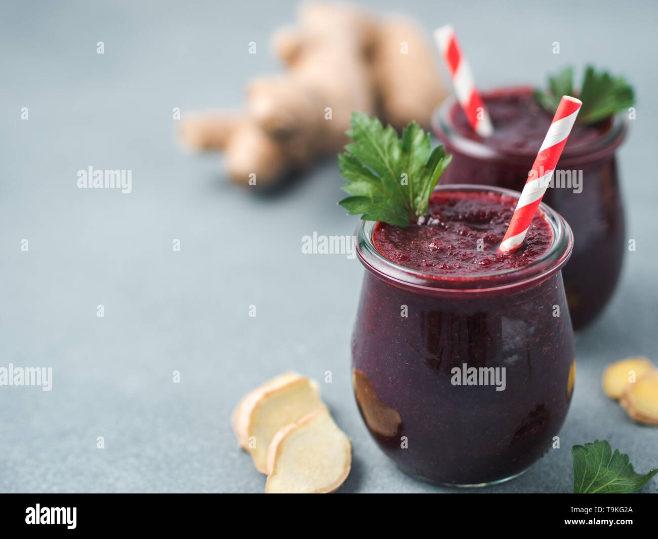 La barbabietola rossa fresca e radice di zenzero frullato. Frullato di barbabietole in un barattolo di vetro sulla tabella grigia. DOF poco profondo. Copia spazio per il testo. Pulire mangiare e detox concetto, ricetta idea. Foto Stock