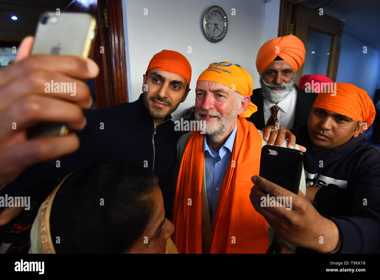 (Centro) leader laburista Jeremy Corbyn in posa per una foto durante una visita a Gurdwara Sri Guru Singh Sabha a Southall. Foto Stock