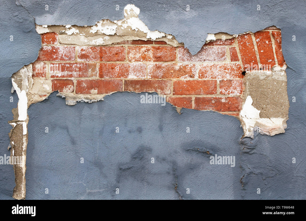 Muro di mattoni con peeling vernice e gesso nella necessità di riparazione Foto Stock