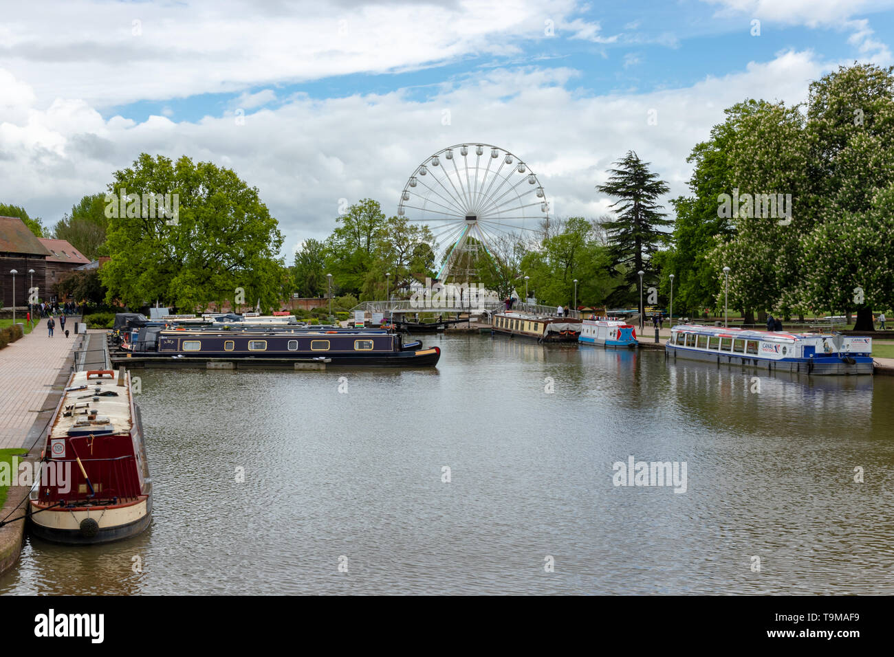 Barche strette ormeggiate al Marina di Stratford Upon Avon Con ruota panoramica dietro Foto Stock