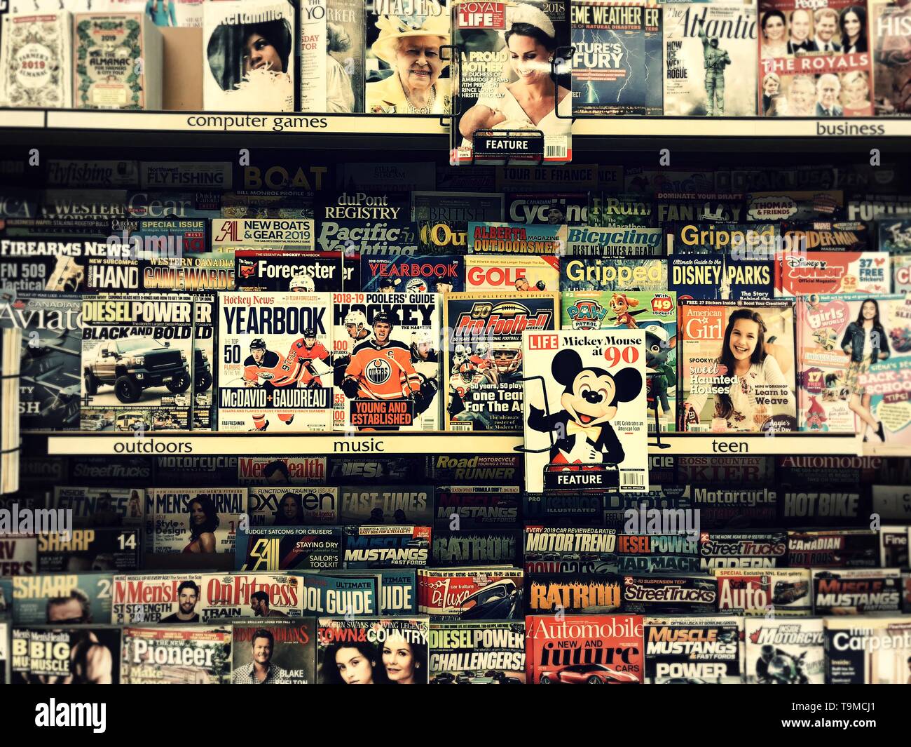 Uno stand di riviste in un supermercato che mostra Topolino nel fuoco primario. Foto Stock