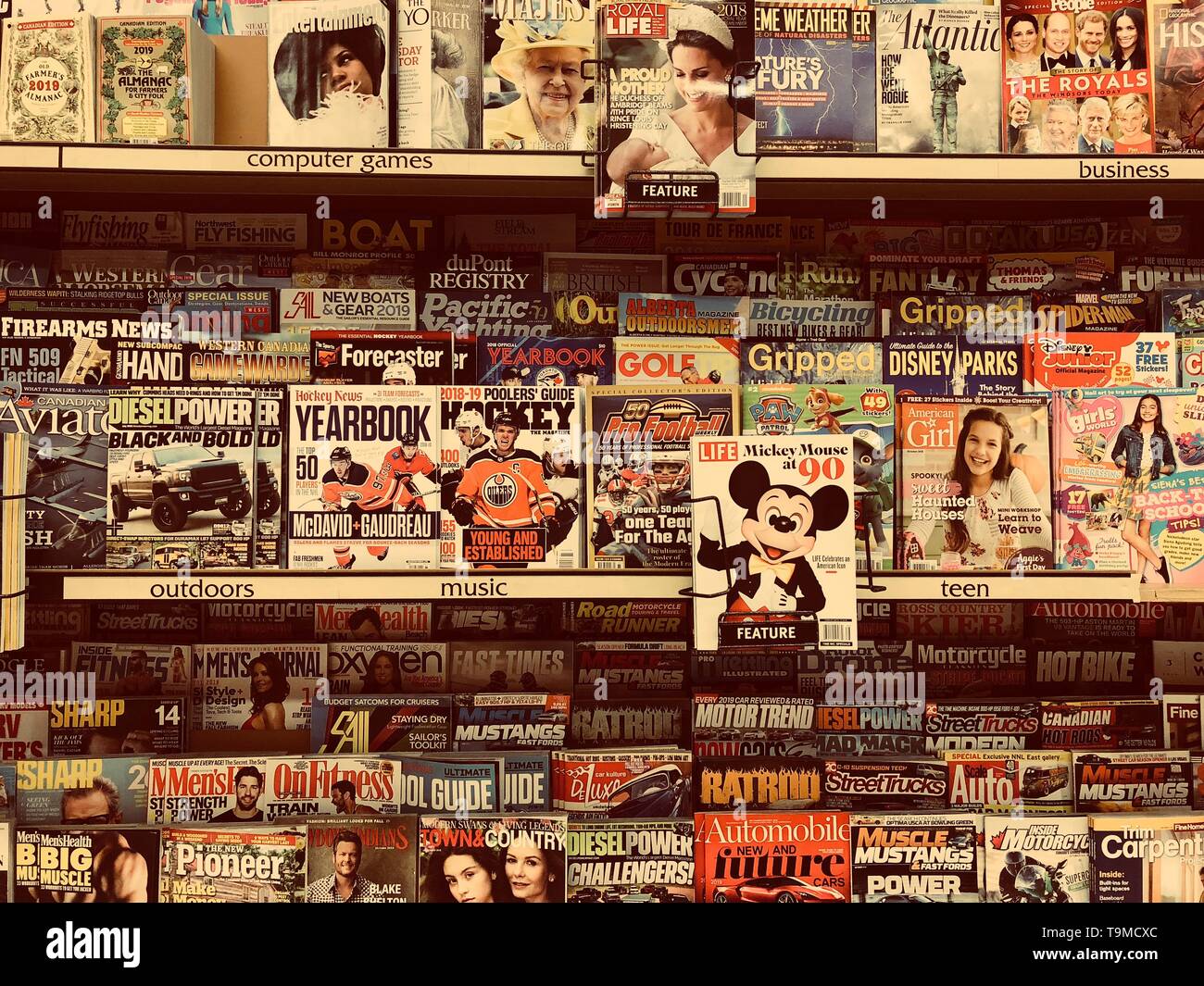 Uno stand di riviste in un supermercato che mostra Topolino nel fuoco primario. Foto Stock