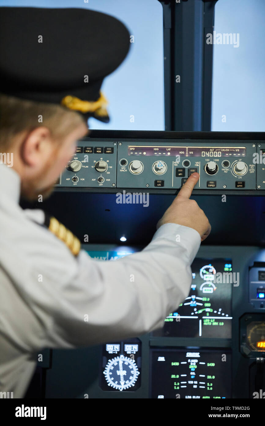 Capitano dell'aereo premendo il pulsante Foto Stock