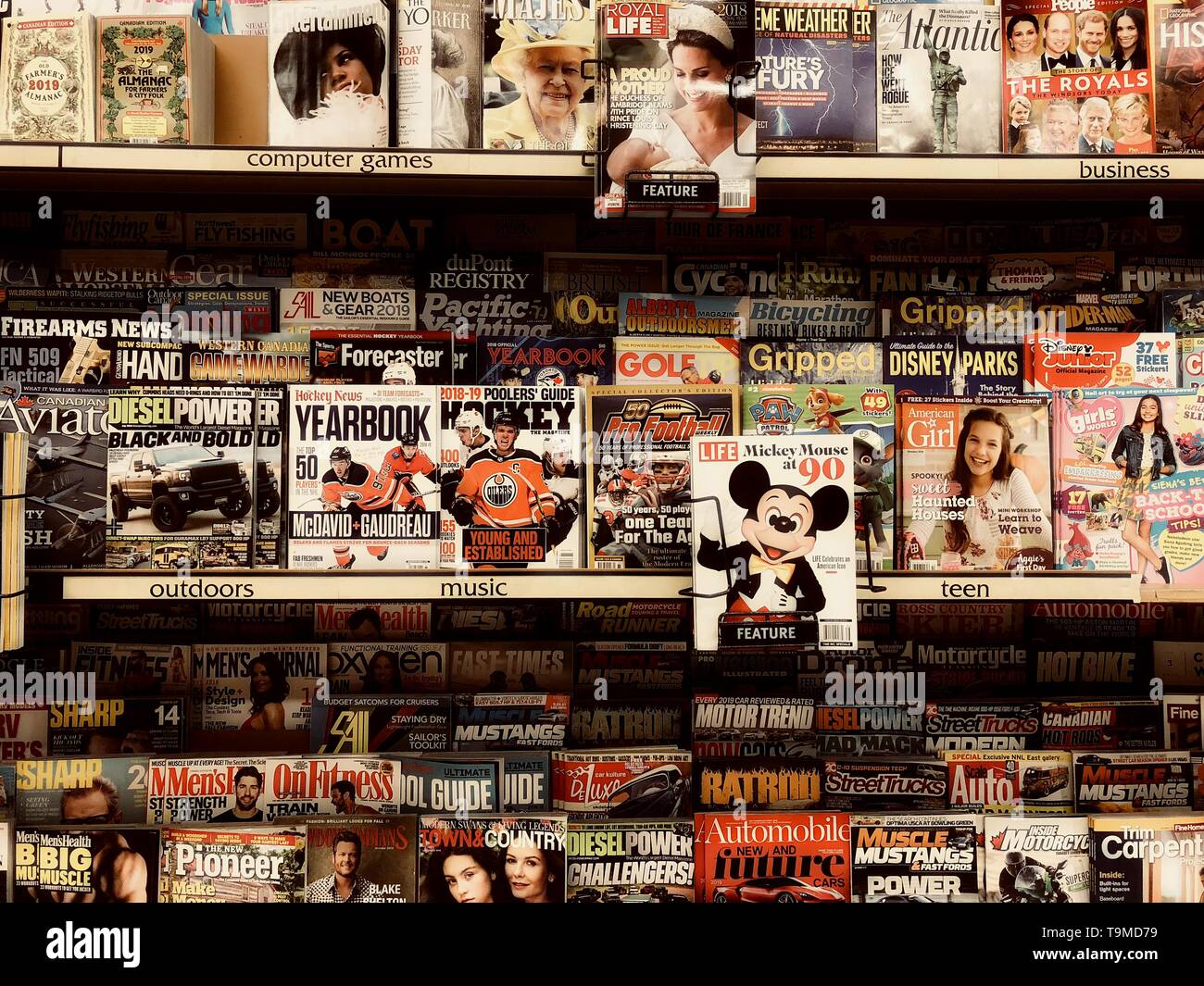 Uno stand di riviste in un supermercato che mostra Topolino nel fuoco primario. Foto Stock