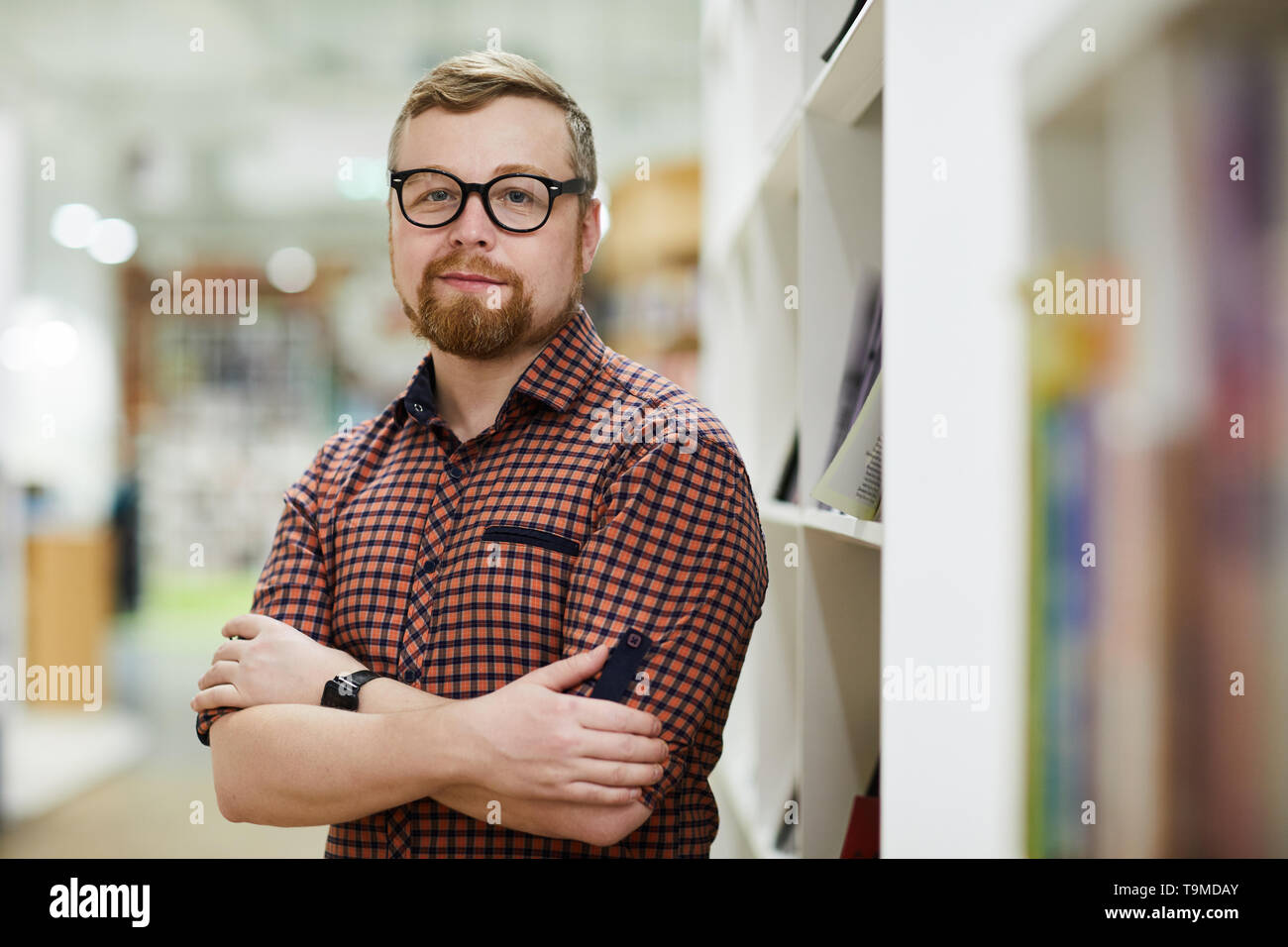 Fiducioso barbuto bookstore manager Foto Stock