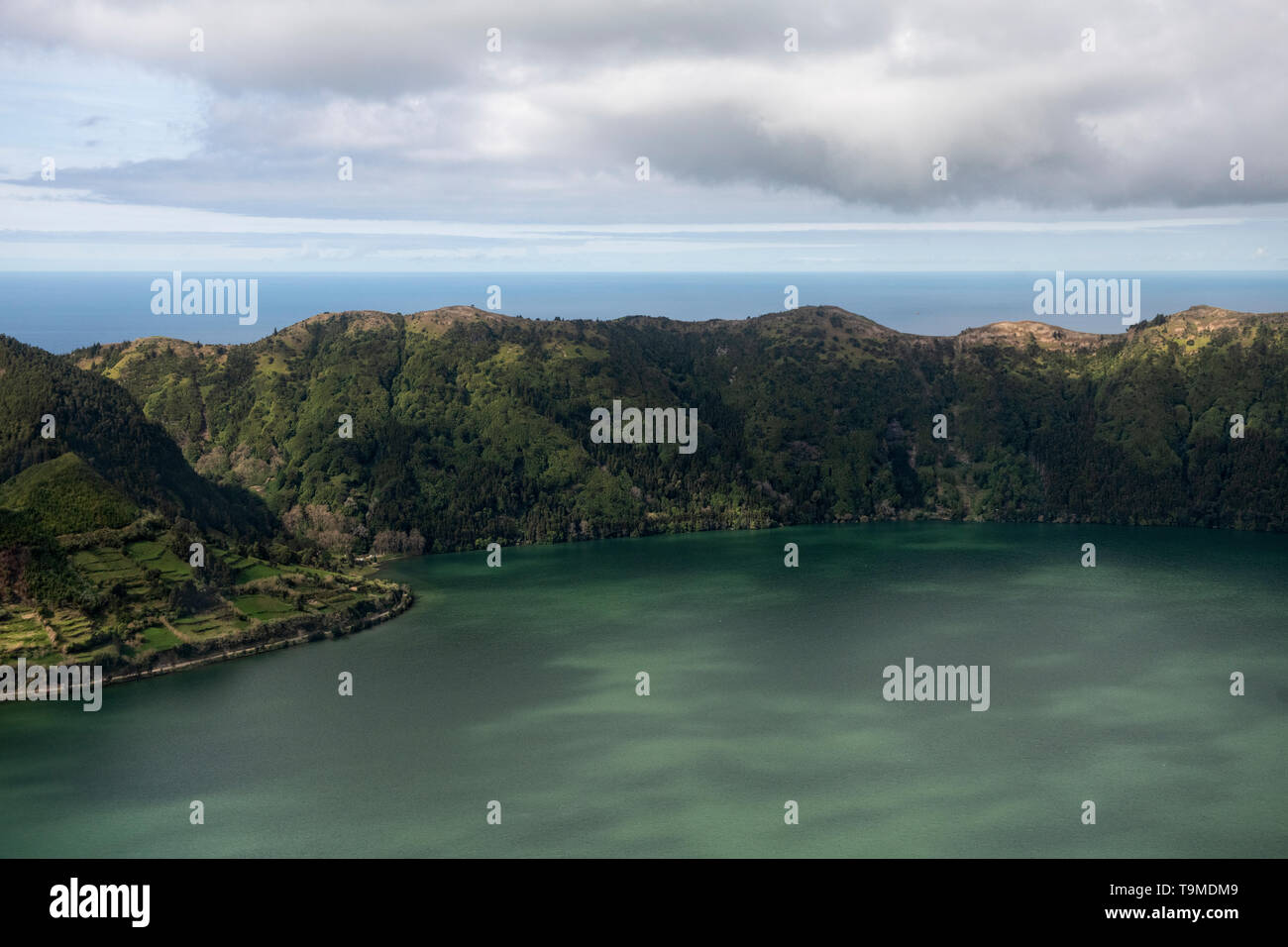 Paesaggio dell'antenna dell'imponente cratere vulcanico con Lagoa Azul a Sete Cidades con l'oceano dietro la parete del cratere, Isola di Sao Miguel, Azzorre Foto Stock