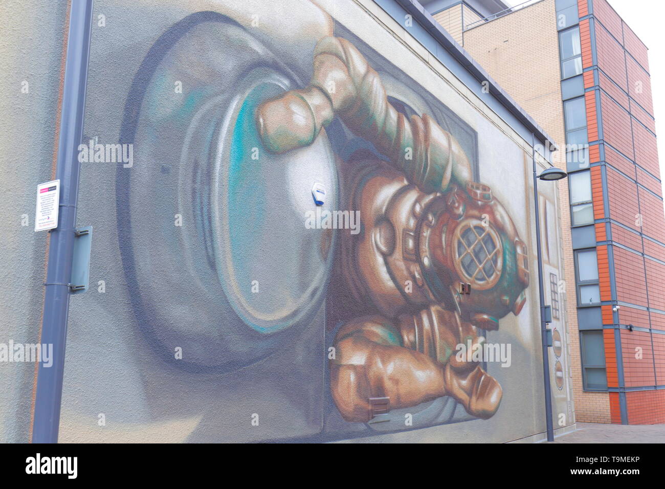 Un dipinto murale di un mare profondo subacqueo arrampicata su di una macchina di lavaggio su blocchi di appartamenti in Brewery Wharf,Leeds, West Yorkshire. Foto Stock