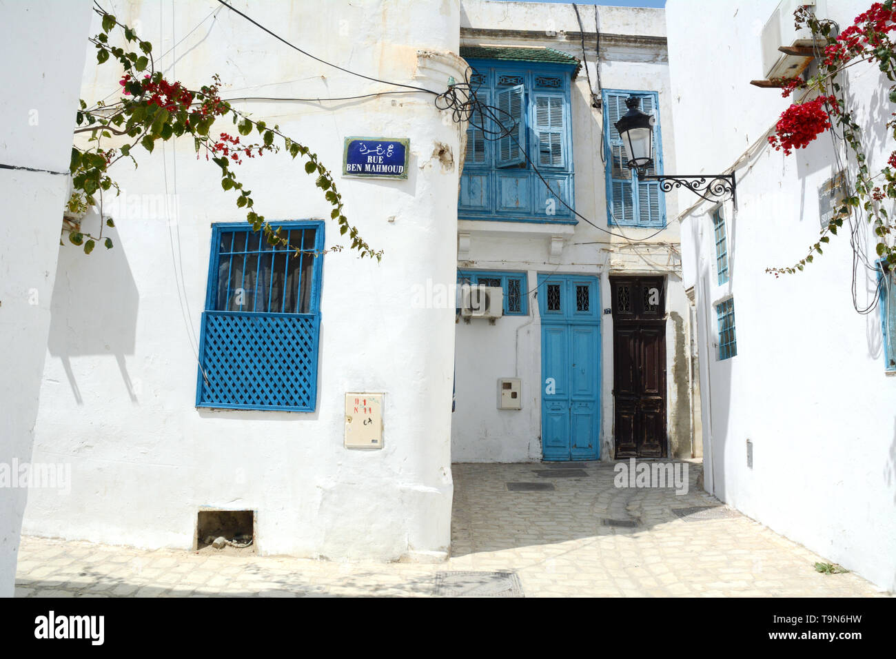 L'esterno pareti dipinte di bianco di una casa privata e l aria aperta street in un quartiere residenziale nel cuore della medina (città vecchia) di Tunisi, Tunisia Foto Stock