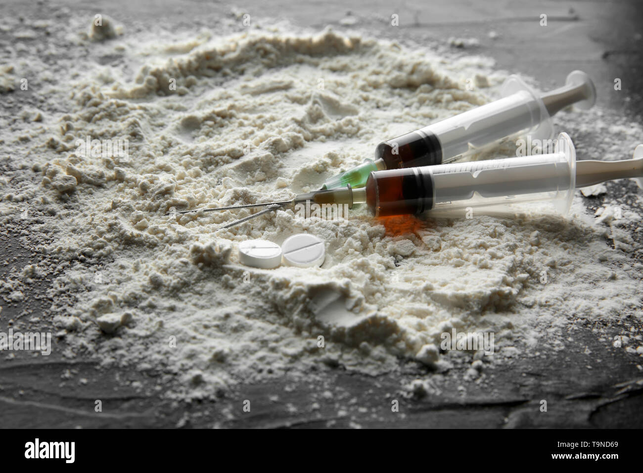 La cocaina con siringhe sul tavolo scuro. Concetto di dipendenza Foto Stock