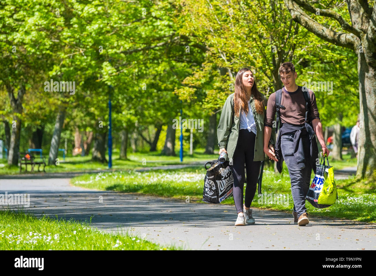 Aberystwyth Wales UK, lunedì 20 maggio 2019 UK Meteo: un giovane godendo di un'ora di pranzo a piedi lungo il viale alberato di Park Avenue nel caldo pomeriggio di sole in Aberystwyth Wales Photo credit: Keith Morris / Alamy Live News Foto Stock