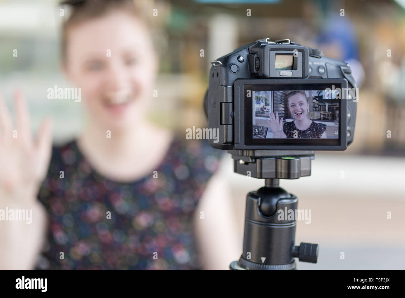 Un caucasian giovane ragazza facendo un video blog (vlog) dietro la telecamera Foto Stock