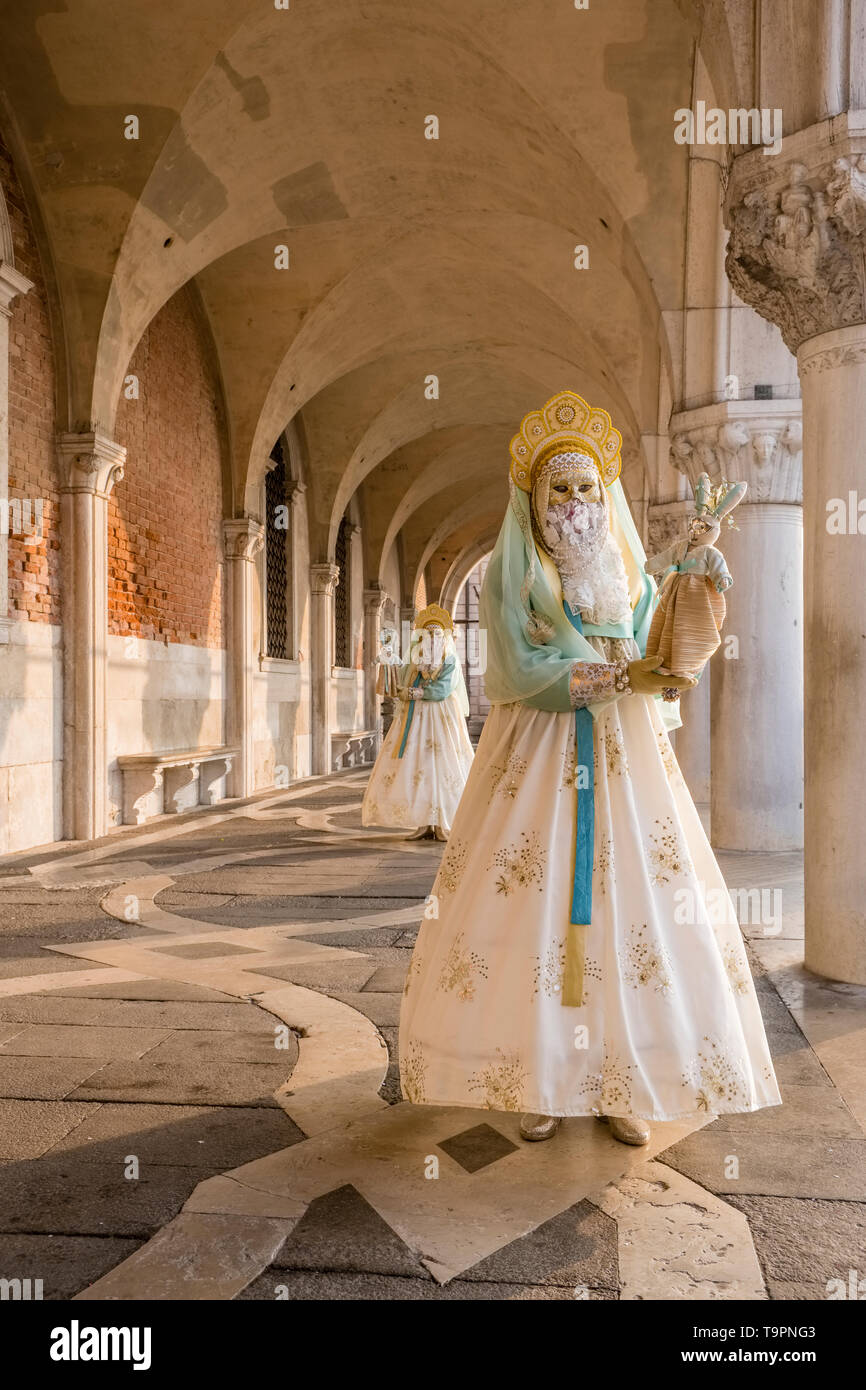 Ritratto di un feminin persona mascherata in un bellissimo costume di creative, ponendo sotto i portici di Palazzo Ducale, Palazzo Ducale Foto Stock