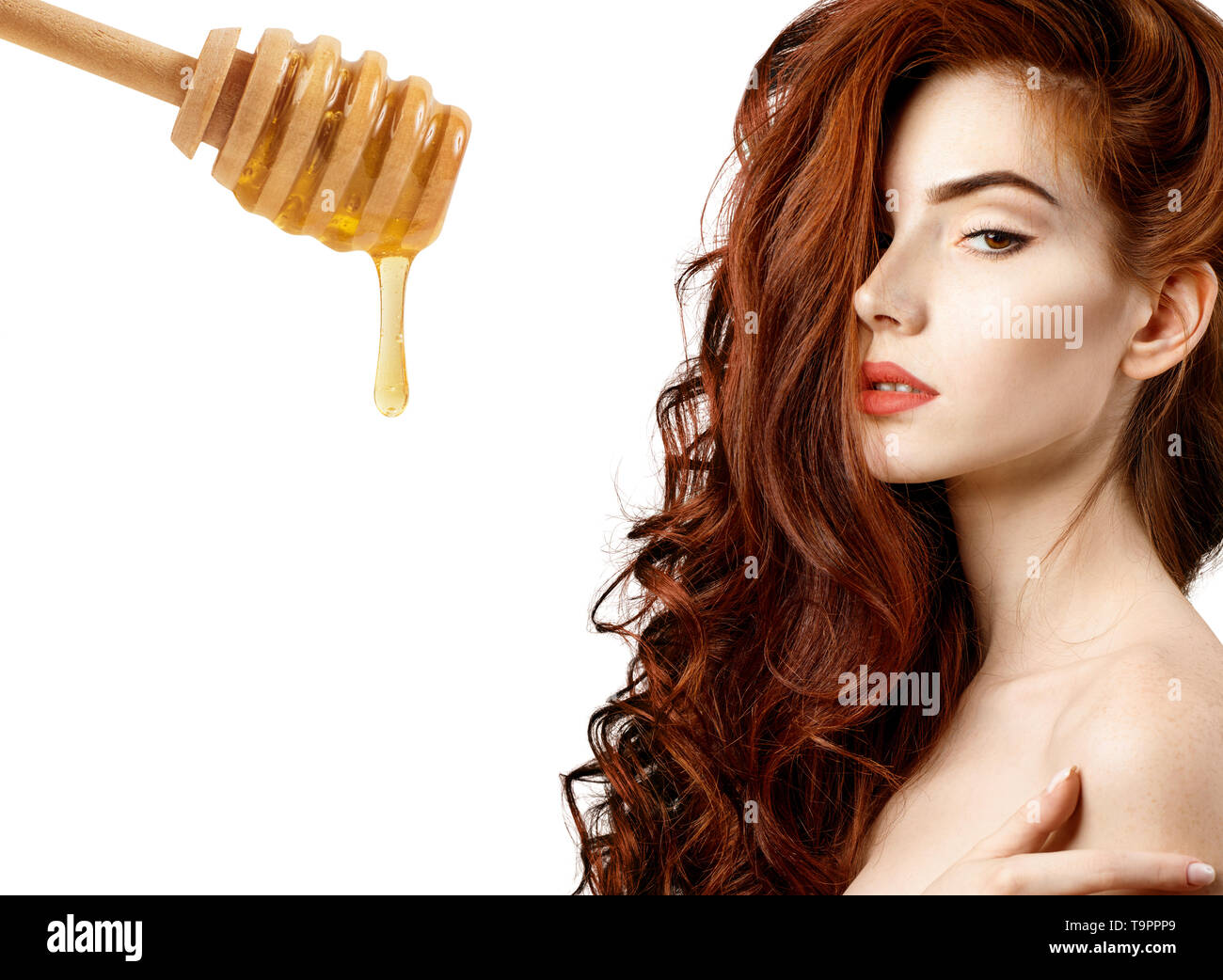 Donna con cucchiaio di miele preparare per la maschera per capelli. Foto Stock